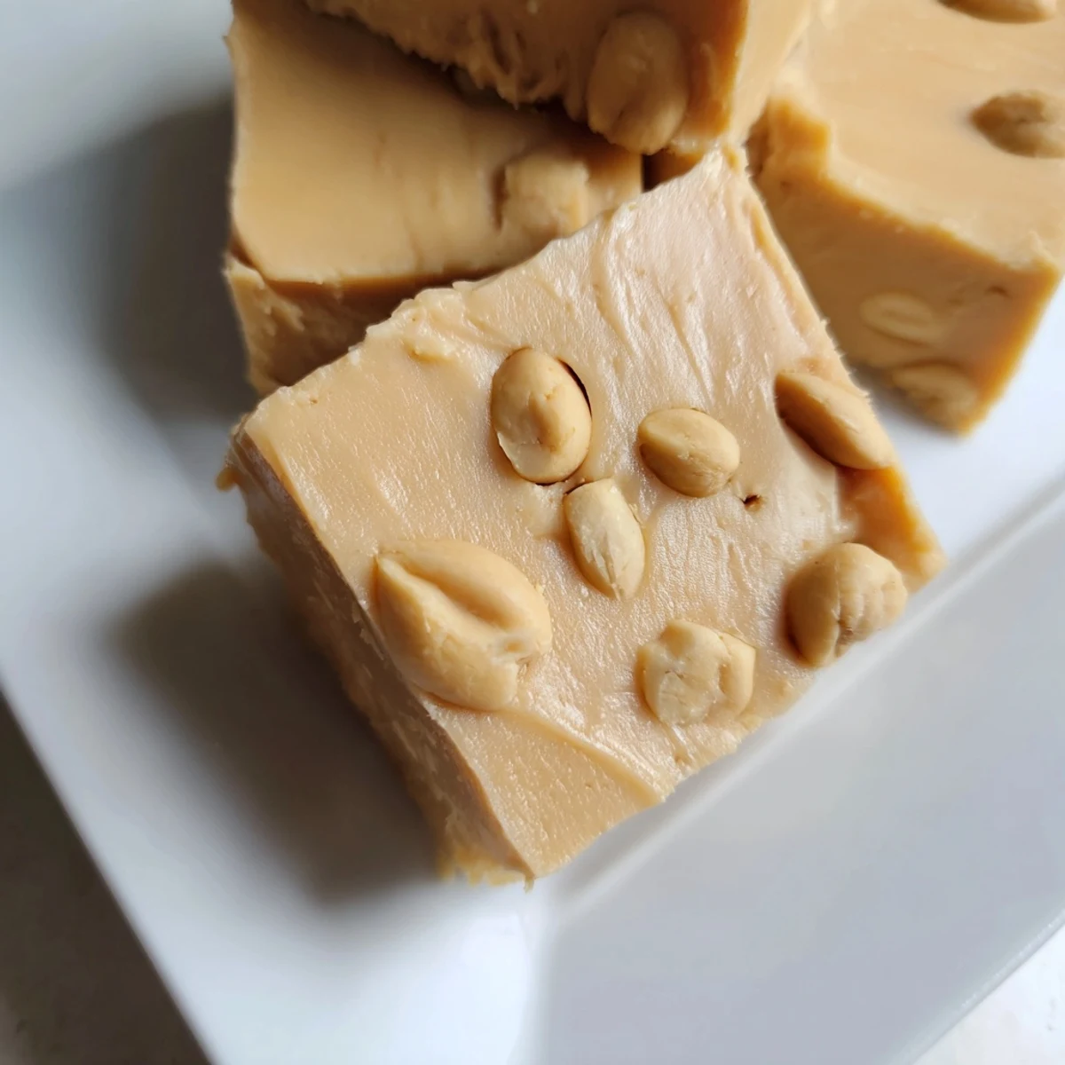 Homemade peanut butter fudge recipe, cut into neat squares, offering a delightful creamy and sweet treat.