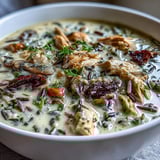 Creamy Parmesan Mushroom Chicken and Wild Rice Soup ladled into rustic bowls, topped with fresh parsley and extra grated Parmesan cheese.