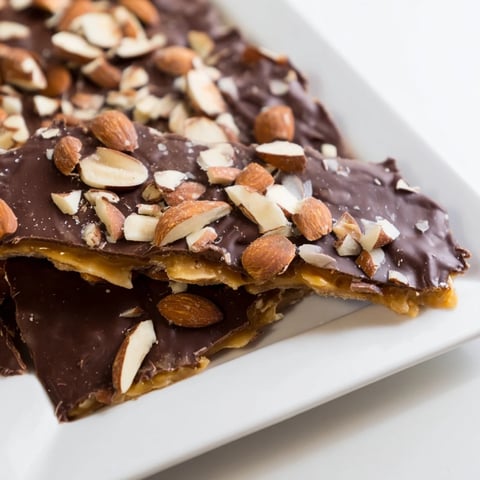 Golden, crispy English toffee, glistening with milk chocolate and scattered toasted almonds, ready to enjoy.