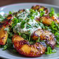 Grilled peaches and creamy burrata combine in a colorful salad, drizzled with honey for a sweet finish.