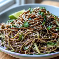 Chilled soba noodle salad with sesame ginger dressing, a vibrant, crunchy veggie medley.
